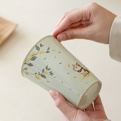 Handcrafted ceramic coffee mug with cat and osmanthus design styled in a home setting